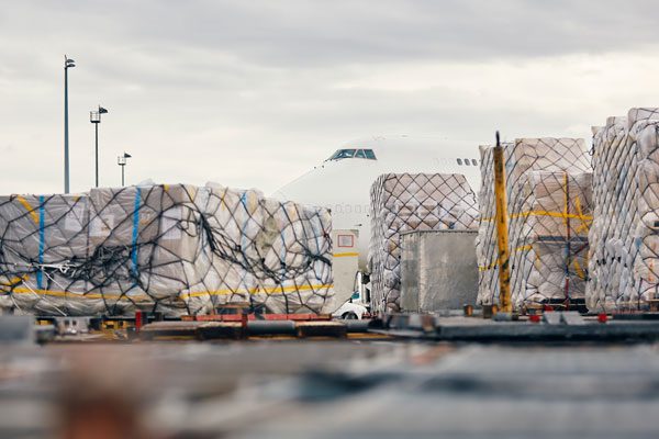 a view of multiple large cargo pallets with an airplane near