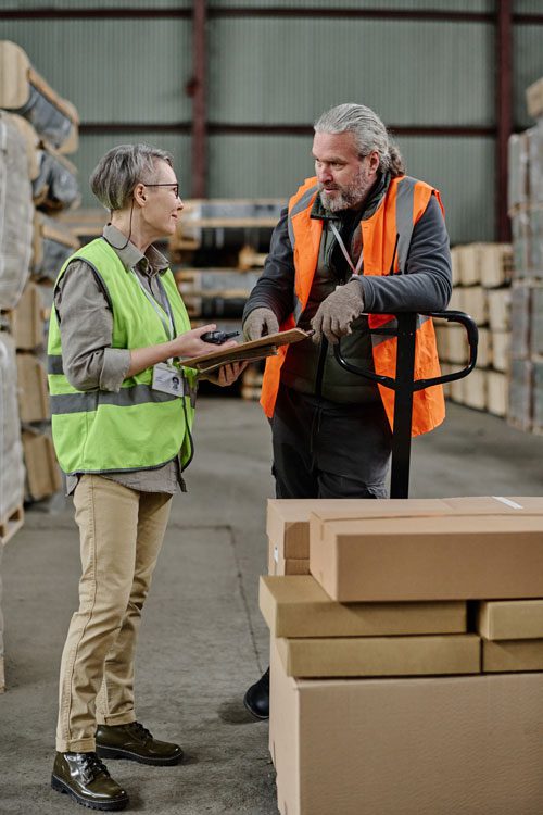 a female manager and a male warehouse worker talking