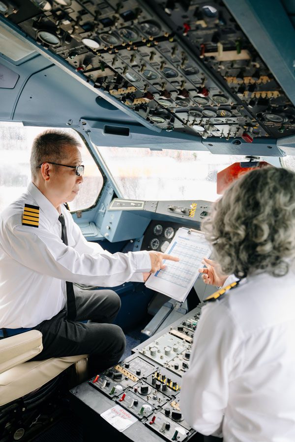 pilot and co pilot looking at a paper in the plane cockpit