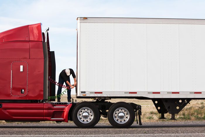 a truck driver getting load ready to be connected to to semi-truck.