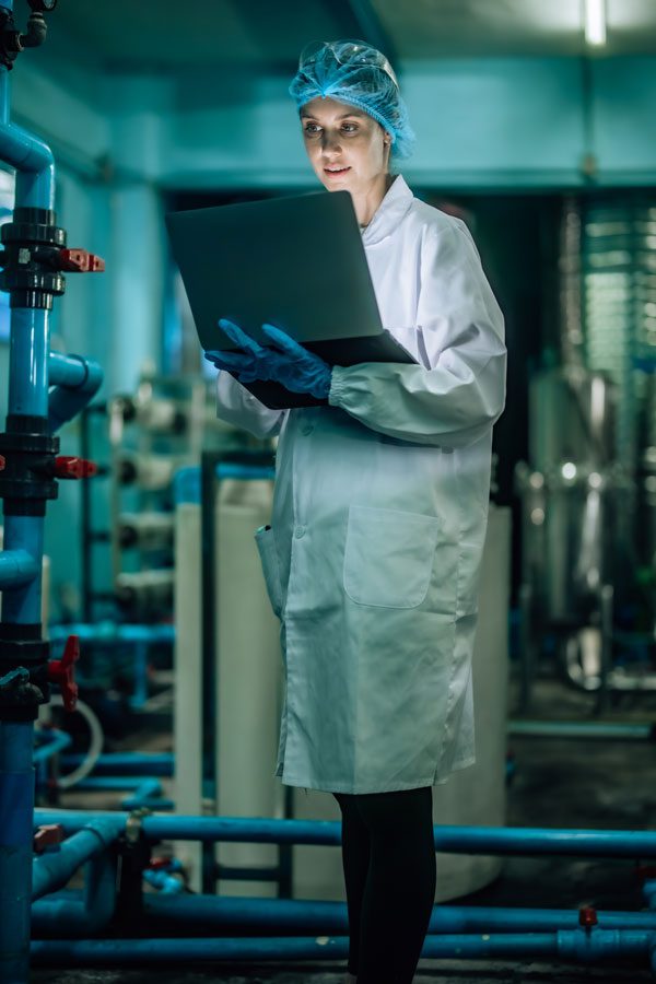 a woman with a white lab coat and monitor 