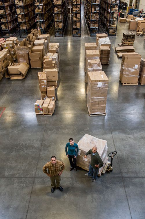 a group of 3 people standing in warehouse of cargo