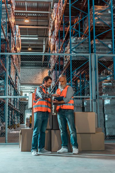 2 men checking a list in a warehouse