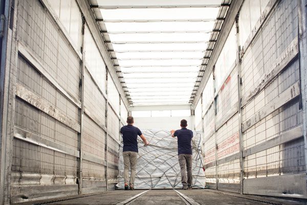 2 men carefully handling cargo 